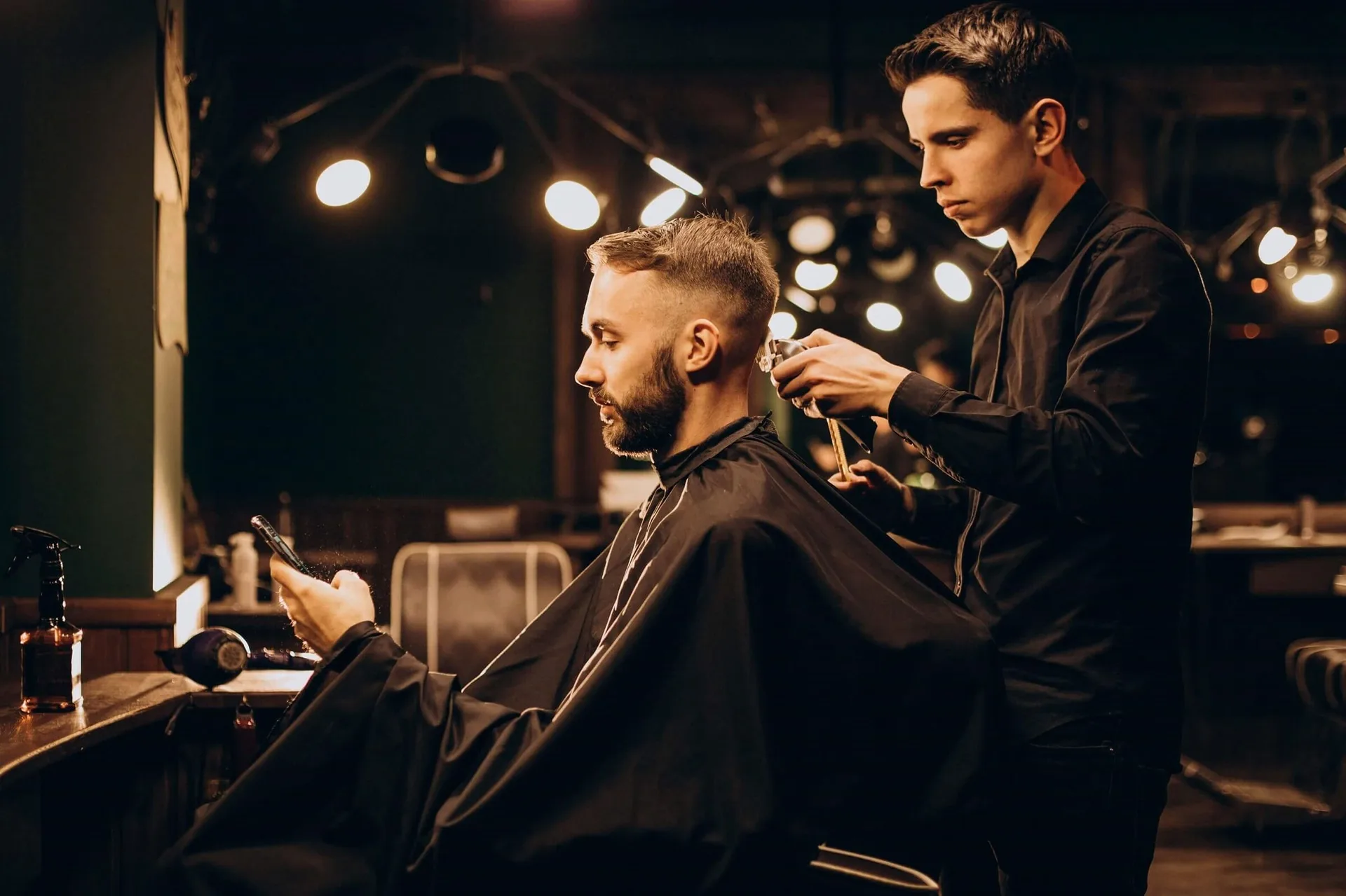 Barbeiro finalizando um corte em um estúdio de iluminação quente